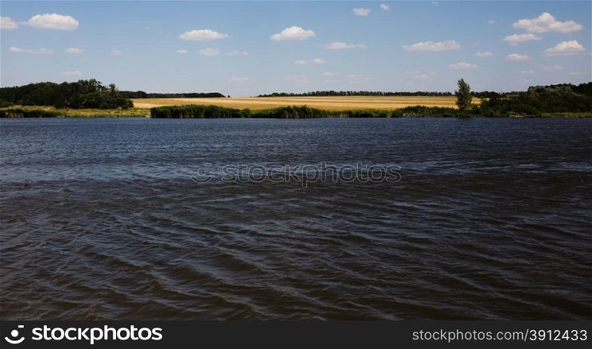 Summer landscape with river and cloudy sky