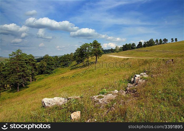 summer landscape with stones and road on hill