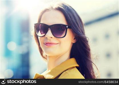 summer, leisure, vacation and people concept - smiling young woman with sunglasses in city. smiling young woman with sunglasses in city