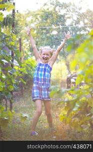 summer - Little girl having fun in the garden under rain