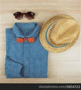 summer male clothing. Top view collection of summer male clothing on the wooden background