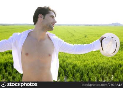 Summer man open shirt outdoor meadow with white hat in hand
