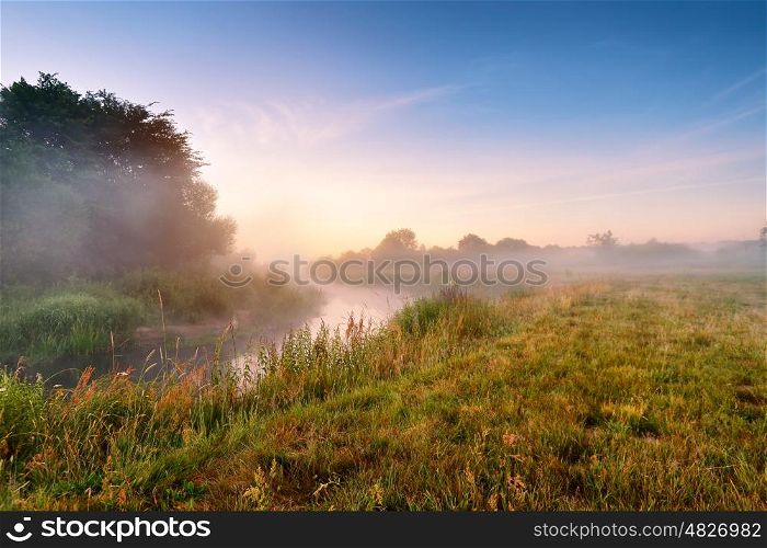 Summer misty sunrise on the river. Foggy river in the morning. Summer misty dawn. Foggy morning.