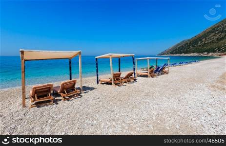 Summer morning beach with aquamarine water and sunbeds (Albania).
