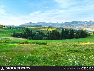 Summer morning mountain village outskirts and Tatra range behind (Gliczarow Gorny, Poland)