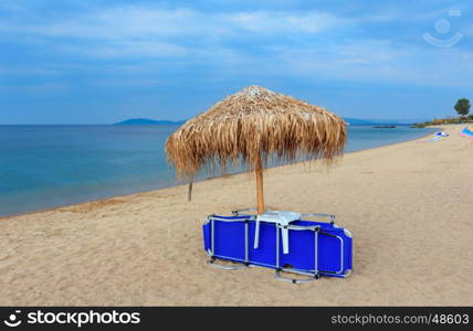 Summer morning sandy Tristinika beach with sunbeds and sunshade (Sithonia, Chalkidiki, Greece).