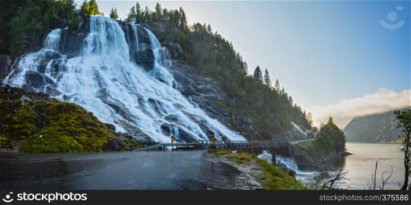 Summer mountain Furebergsfossen waterfall on rocky slope near road along the Hardangerfjord fiord, Mauranger, Norway