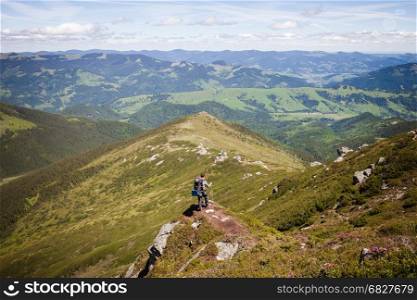 Summer mountain landscape with man standing on the rocky hill