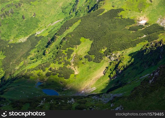 Summer mountain landscape with small lake in far. View from Marmaros Pip Ivan Mountain, Carpathian, Ukraine.