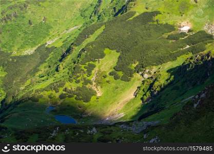 Summer mountain landscape with small lake in far. View from Marmaros Pip Ivan Mountain, Carpathian, Ukraine.