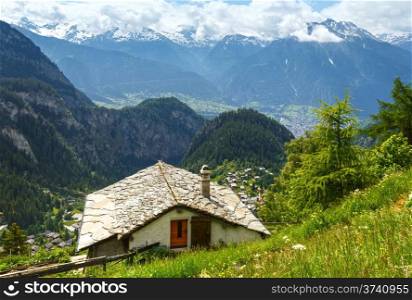Summer mountain landscape with snow on mount top and house on slope (Alps, Switzerland)