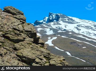 Summer mountain landscape with snow on slope (Sierra Nevada National Park, near Granada, Spain).