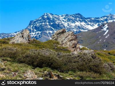Summer mountain landscape with snow on slope (Sierra Nevada National Park, near Granada, Spain).