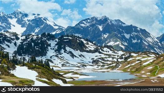 Summer mountain panorama to small Kalbelesee lake and snow thawing meadow (Warth, Vorarlberg, Austria).