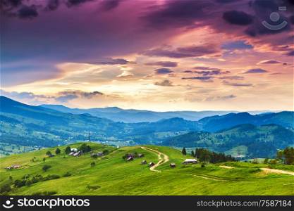 Summer mountain rural landscape, awesome evening sunset view on village and meadow. Colorful evening in mountain valley. Beauty of nature background. Europe travel, Carpathians, Ukraine.