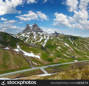 Summer mountain sunny landscape with snow on slope, Warth, Austria. Car models unrecognizable.
