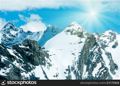Summer mountain view from Stelvio pass (Italy) with snow on slope and sunshine in blue sky