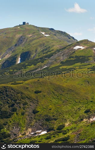 Summer mountain view with snow on mountainside (with observatory ruins on Chornogora Ridge, Ukraine)