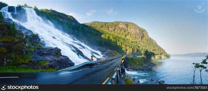 Summer mountain waterfall on slope near road along the Sandvinvatnet lake (Norway). Panorama.