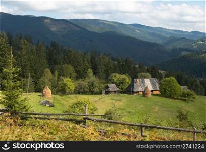 Summer mountainous green glade with small country estate (Slavske village, Carpathian Mts, Ukraine).