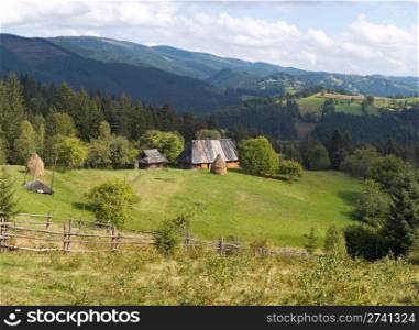 Summer mountainous green glade with small country estate (Slavske village, Carpathian Mts, Ukraine). Four shots composite picture.