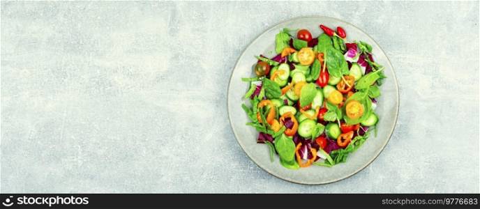 Summer natural salad of tomatoes, cucumbers, peppers and spinach. Vegetarian food, copy space. Bright, colorful vegetable salad