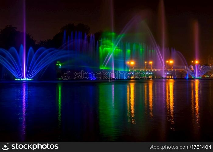 Summer night in the city. Fountain on the river with lights. City Fountain with Night Illumination
