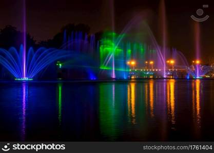Summer night in the city. Fountain on the river with lights. City Fountain with Night Illumination