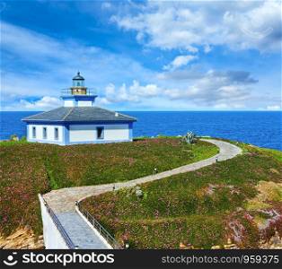 Summer ocean island Pancha coastline landscape with lighthouse and pink flowers (Spain).