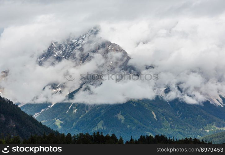 Summer overcast mountain top in clouds view from Fernpass, Austria, near Zugspitze mountain.