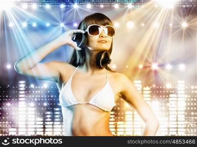 Summer party. Young pretty girl in white bikini and headphones