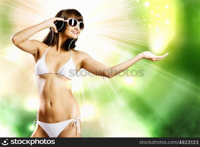 Summer party. Young pretty girl in white bikini and headphones