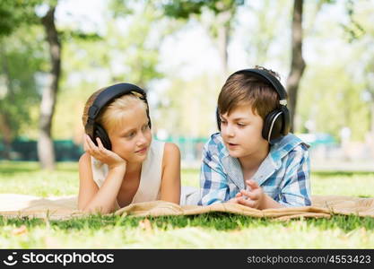 Summer picnic in park. Cute boy and girl in summer park listening to music