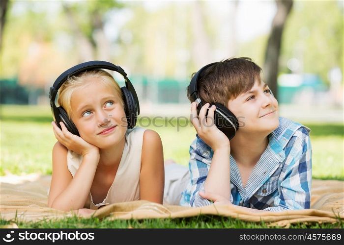 Summer picnic in park. Cute boy and girl in summer park listening to music