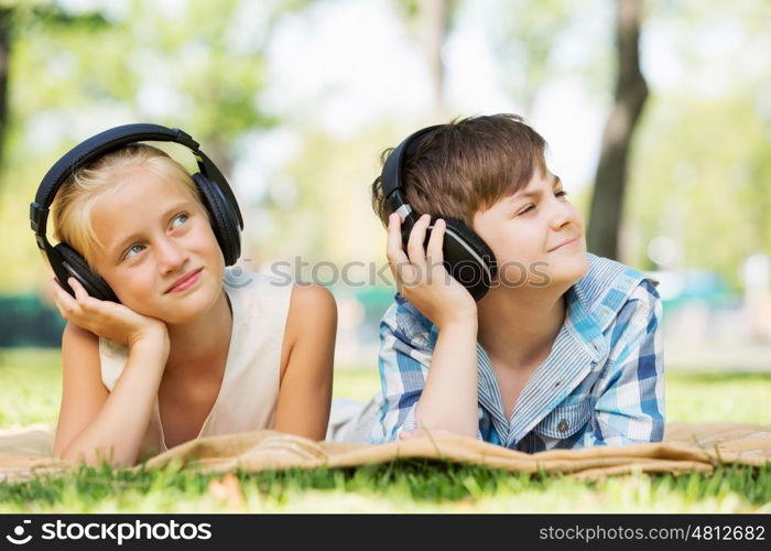 Summer picnic in park. Cute boy and girl in summer park listening to music