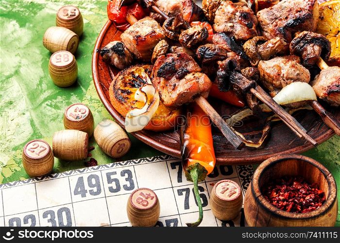 Summer picnic with shashlik and lotto board game.Barbecue and board games.Kebab. BBQ meat and lotto game