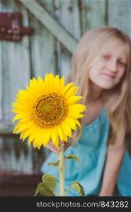 summer - portrait of a little smiling girl with a sunflower