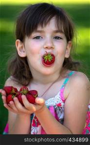 Summer - portrait of a smiling girl with a strawberry in hands