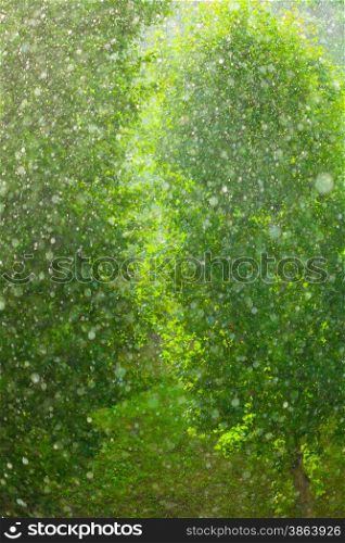 Summer rainy outside window, water drops droplets raindrops on glass windowpane as background texture. Downpour rain.