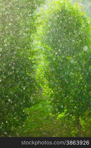 Summer rainy outside window, water drops droplets raindrops on glass windowpane as background texture. Downpour rain.