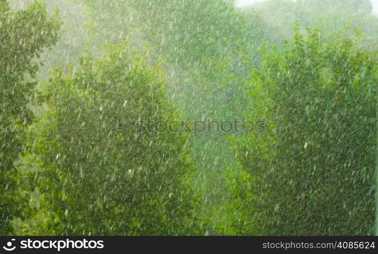 Summer rainy outside window, water drops droplets raindrops on glass windowpane as background texture. Downpour rain.