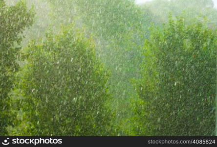 Summer rainy outside window, water drops droplets raindrops on glass windowpane as background texture. Downpour rain.