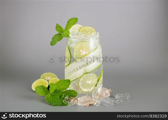 summer refreshing drinks, homemade lemonade made from lime, lemon, cucumber and  mint with ice in glass on an old concrete background. selective focus.