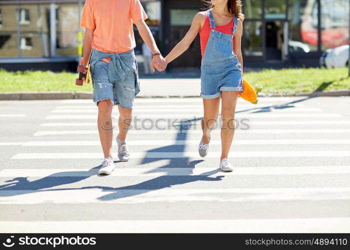 summer, relations, traffic, extreme sport and people concept - happy teenage couple with short modern cruiser skateboards crossing city crosswalk