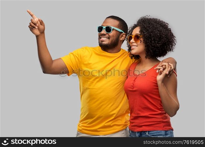 summer, relationships and people concept - happy african american couple in sunglasses over grey background. happy african american couple in sunglasses