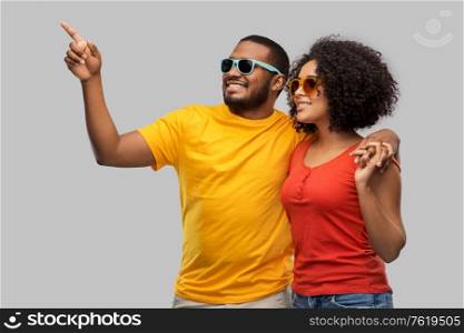 summer, relationships and people concept - happy african american couple in sunglasses over grey background. happy african american couple in sunglasses