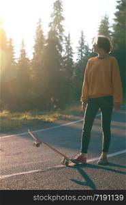 Summer Road Trip. beautiful landscape and view of a mountain road. girl rides on a skateboard at the transalpine. Romania.