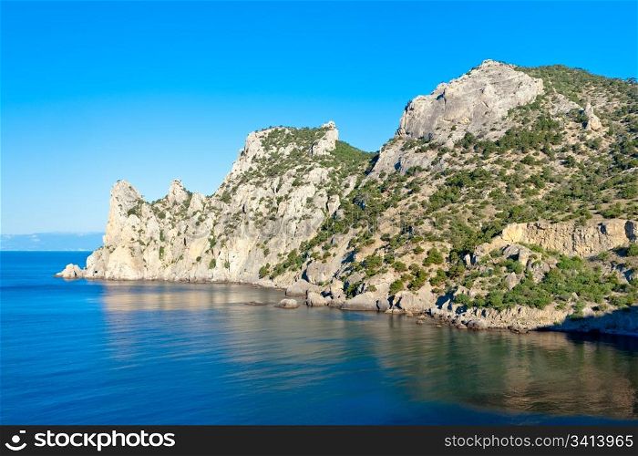 "Summer rocky coastline with juniper trees ("Novyj Svit" reserve, "Rhinoceros" cape, Crimea, Ukraine)."