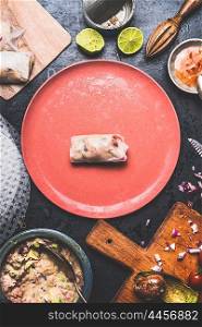 Summer rolls with canned tuna fish filling, preparation on rustic kitchen table with plates, tolls and ingredients, top view
