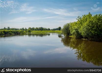 Summer rural landscape with river and blue sky background.